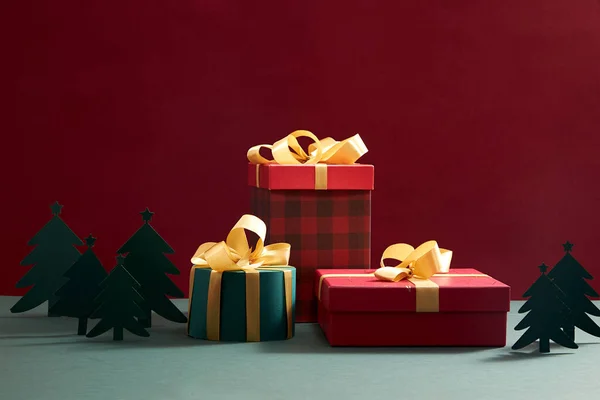 クリスマスギフトボックス広告 写真の休日のコンテンツのための空白のスペースと緑の背景に黄色のリボンとクリスマスの飾りと緑と赤 — ストック写真