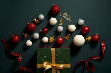 Koyu mavi arka plan, sürpriz hediye kutusu dolusu Noel süsü, şeker kırmızısı kurdele renkli pırıltılı inci, Noel tatili içeriği