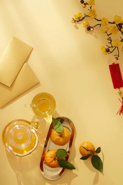 中国新年 有柑橘茶壶和糖果 花和红色口袋 黄色背景摄影 节假日内容 中国新年 顶级风景 — 图库照片