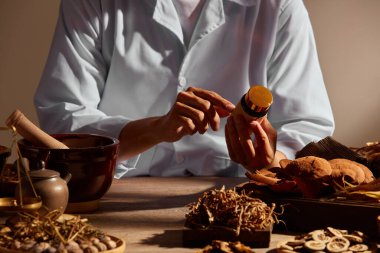 Kahverengi ahşap arka planda bitki ve baharatlı geleneksel Çin tıbbı ve Çin tıbbı içerikli reklamlar için bir doktor.