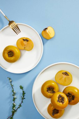 Mavi hurma, domuz eti, bıçak, su bardağı. Açık mavi arka planda yemek reklamı için.