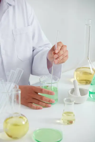 Plants extract in petri dish and a white background in laboratory , color liquid in a test tube and doctor for cosmetic advertising , photography science concept