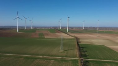 Rüzgar türbinlerinin 4K 'lık hava videosu ve bir elektrik direği.