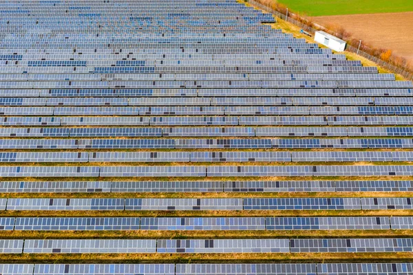 En solcellsanläggning, buskar, åkervägar och ängar med solceller på marken i Tyskland ur drönarsynpunkt — Stockfoto