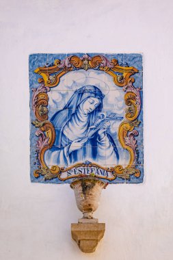 Portekiz 'in Obidos şehrinde bir ev duvarında Azulejos adı verilen 42 boyalı seramik fayanstan yapılmış kutsal Sta Estefania' nın duvar resmi.