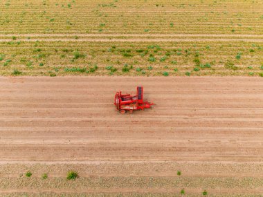 A red harvester on a dry field after harvest, Hesse, Germany