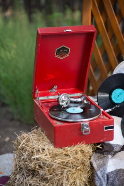 Plakları olan eski kırmızı taşınabilir gramofon.