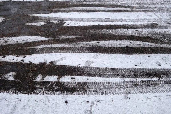 車の刻印とアスファルトの道路上の雪 デザインの季節の背景と質感 — ストック写真