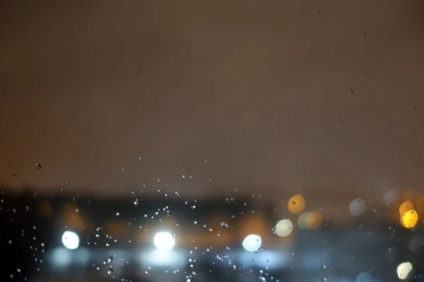从窗户望去 夜城上有雨滴 摘要模糊背景 — 图库照片