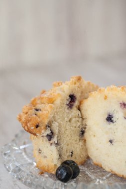 Yaban mersinli kek ikiye bölündü ve cam tabağa kondu.