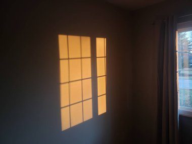 A shadow of a window on a indoor wall