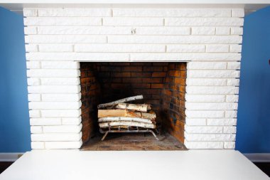 Mavi duvarlara karşı beyaz bir şömine.