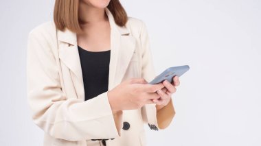Beyaz arka planda akıllı telefon kullanan takım elbiseli güzel bir kadının portresi.