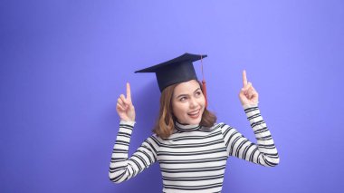 Mavi arka planda mezun olmuş genç bir kadının portresi. 