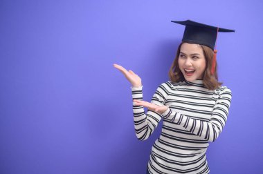 Mavi arka planda mezun olmuş genç bir kadının portresi. 