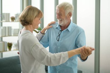 Mutlu beyaz çift evde dans ediyor.