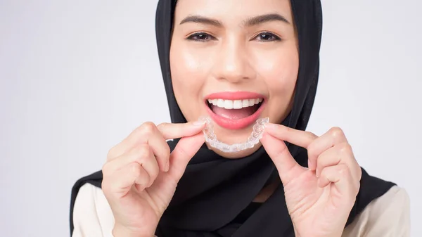 年轻的穆斯林妇女 在演播室 牙科保健和牙齿矫正概念中持有无创矫正器支架 — 图库照片