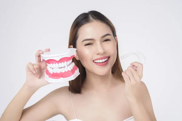 在演播室 牙科保健和牙齿矫正概念方面 年轻的微笑女性手持无拘无束的牙套 — 图库照片