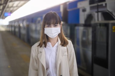 Genç bir kadın metro, covid-19 koruma, güvenlik seyahati, yeni normal, sosyal mesafeler, güvenlik ulaşımı, pandemik konsept altında seyahat ederken koruyucu maske takıyor