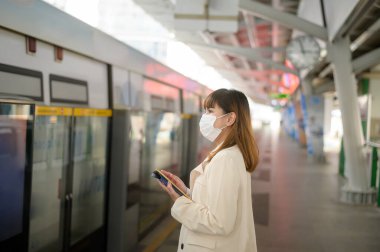Genç bir kadın metro, covid-19 koruma, güvenlik seyahati, yeni normal, sosyal mesafeler, güvenlik ulaşımı, pandemik konsept altında seyahat ederken koruyucu maske takıyor