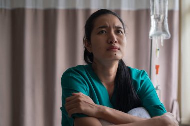 Çaresiz bir Asyalı kadın hasta. Doktorun, kanserin seyrinin sonuna yaklaştığı yönündeki açıklamasının ardından,.