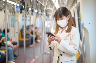 Genç bir kadın metro, covid-19 koruma, güvenlik seyahati, yeni normal, sosyal mesafeler, güvenlik ulaşımı, pandemik konsept altında seyahat ederken koruyucu maske takıyor