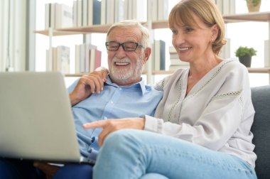 Evde dizüstü bilgisayar kullanan Kafkasyalı mutlu çift.