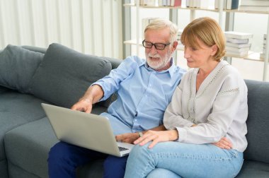 Evde dizüstü bilgisayar kullanan Kafkasyalı mutlu çift.