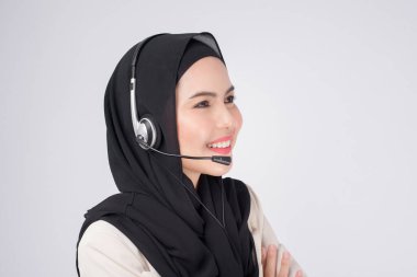 Müşteri hizmetleri operatörü takım elbiseli Müslüman kadın beyaz arka plan stüdyosunun üzerine kulaklık takıyor.