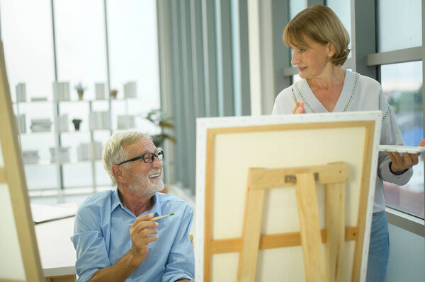 Senior caucasian couple painting and relaxing at home