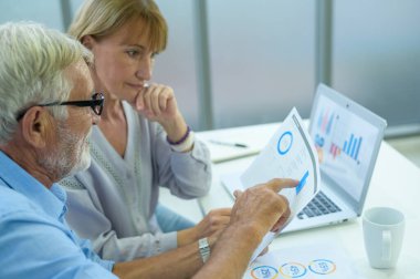 Kafkasyalı üst düzey iş adamları modern ofiste çalışıyor ve beyin fırtınası yapıyorlar.