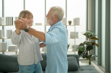 Mutlu beyaz çift evde dans ediyor.