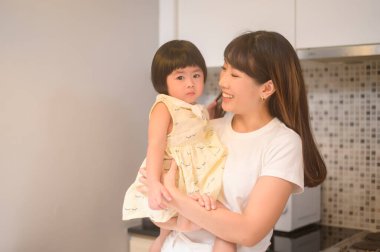 Mutfaktaki mutlu anne ve kızın portresi.