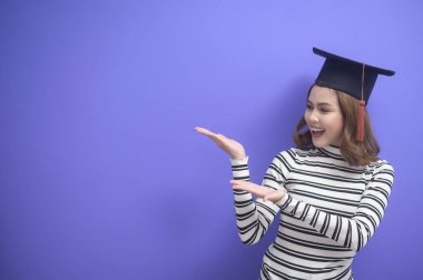Mavi arka planda mezun olmuş genç bir kadının portresi. 