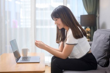 Genç ve güzel bir kadın internet sitesinden alışveriş için kredi kartı kullanıyor. E-ticaret konsepti.