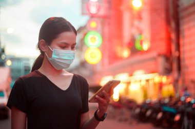 Beautiful woman wearing a surgical mask outdoor, covid-19 , health and pollution concept.	