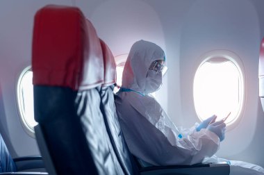 Asyalı bir adam koruyucu kıyafet giyiyor, PPE kıyafeti giyiyor, güvenlik seyahati konsepti. .