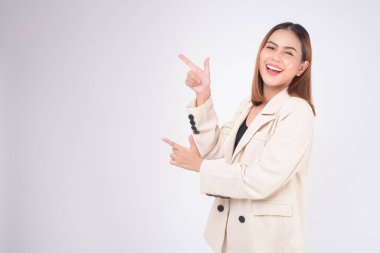 Portrait of young beautiful businesswoman wearing suit in white background studio.	