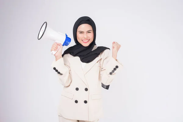 身穿西服的年轻美丽的穆斯林女子的肖像 用扩音器在孤立的白色背景演播室上宣布 — 图库照片