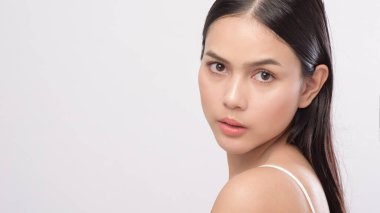 Beyaz arka planda pürüzsüz, sağlıklı bir teni olan genç ve güzel bir kadının portresi.