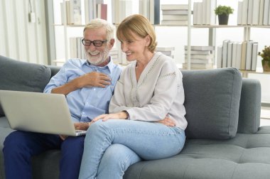 Evde dizüstü bilgisayar kullanan Kafkasyalı mutlu çift.