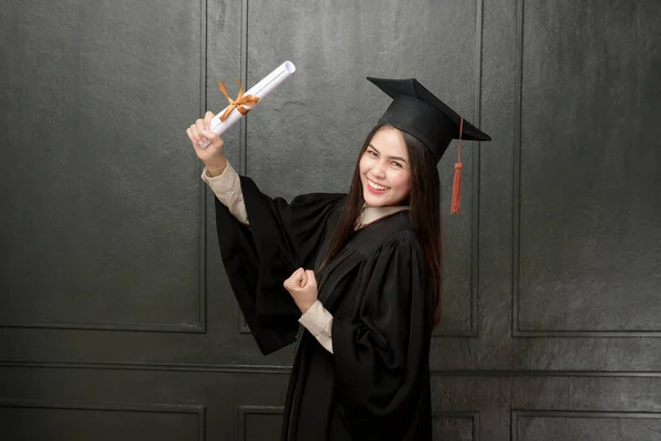 Portrait Young Woman Graduation Gown Smiling Cheering Black Background — Stock Photo, Image