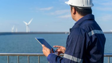 Bir insan mühendisi kafasına koruyucu bir kask takıyor. Tablet Analitik Mühendisliği verilerini kullanıyor..