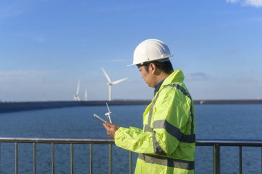 Bir insan mühendisi kafasına koruyucu bir kask takıyor. Tablet Analitik Mühendisliği verilerini kullanıyor..