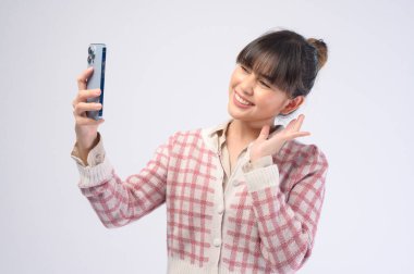 Genç ve güzel bir kadın akıllı telefon kullanıyor.