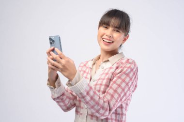 Genç ve güzel bir kadın akıllı telefon kullanıyor.