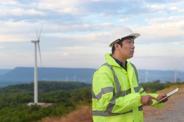 Bir insan mühendisi kafasına koruyucu bir kask takıyor. Tablet Analitik Mühendisliği verilerini kullanıyor..