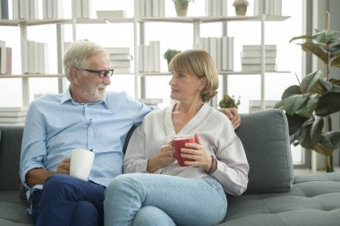 Mutlu Kafkasyalı son sınıf çifti evde kahve içiyor, rahatlatıcı ve sağlık hizmeti konsepti. .