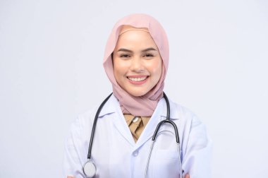 Beyaz arka plan stüdyosu üzerinde tesettüre sahip bir kadın Müslüman doktor..
