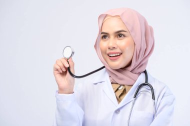 Beyaz arka plan stüdyosu üzerinde tesettüre sahip bir kadın Müslüman doktor..